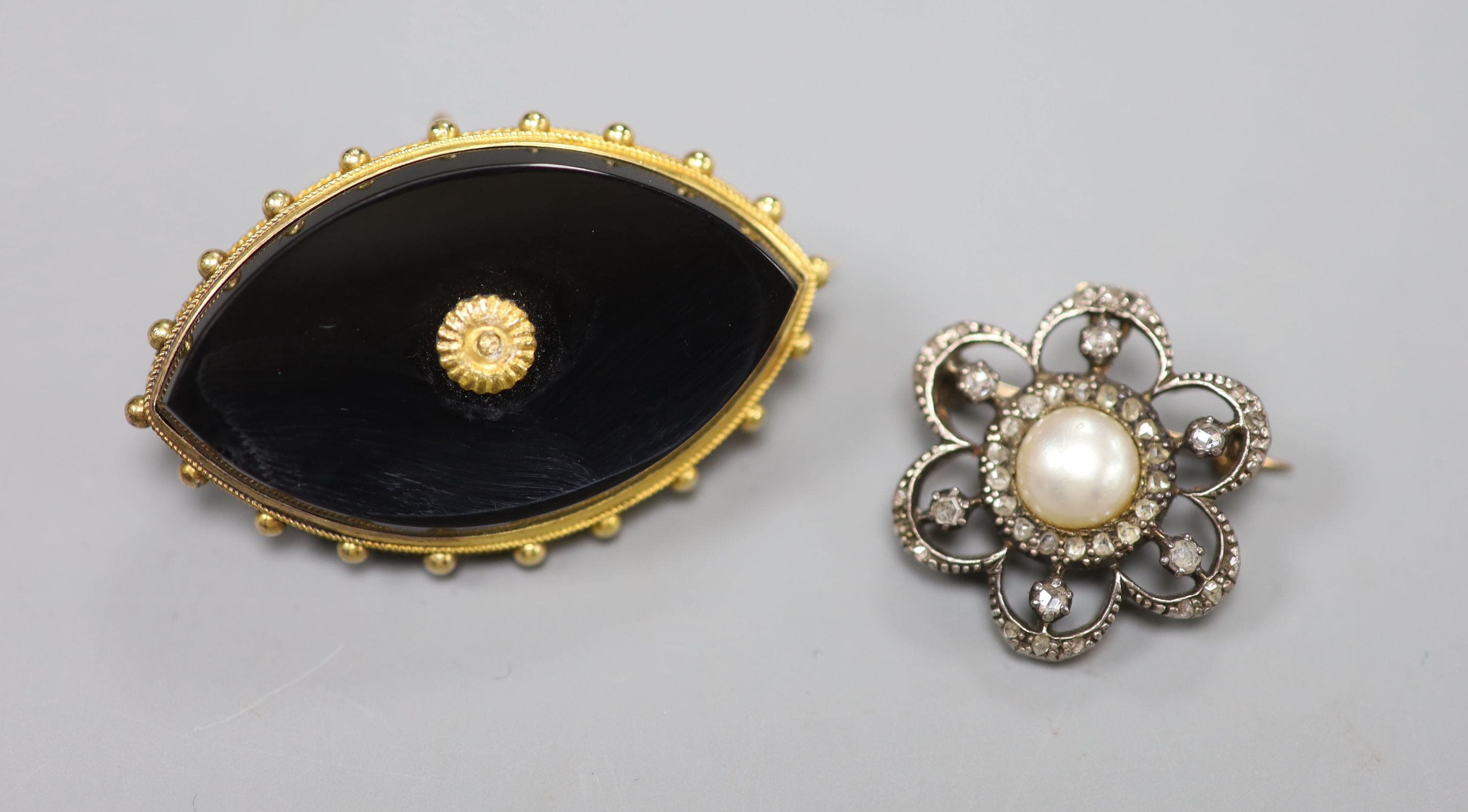 A Victorian yellow metal and onyx navette-shaped mourning brooch and a rose diamond and pearl openwork cluster brooch (2)